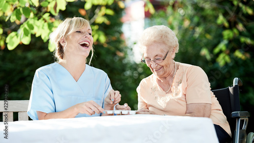 Fotografía Pflegerin und Seniorin im Garten