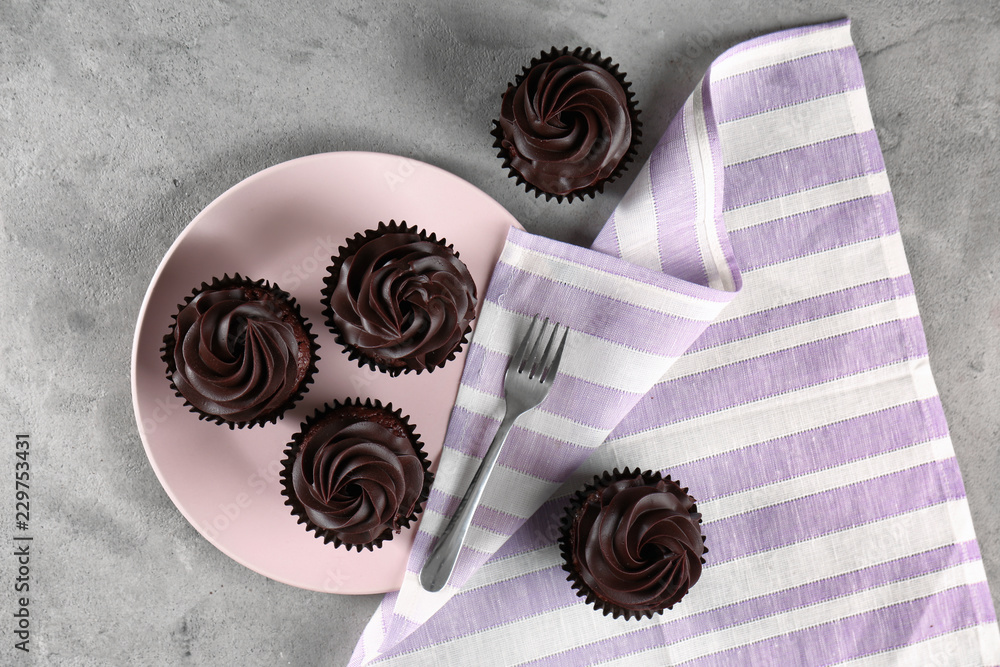 Tasty chocolate cupcakes on grey table