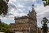 Fototapeta Londyn - The Bussaco Palace Hotel under a blue sky with white clouds