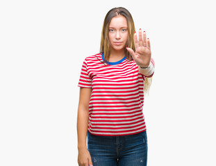 Young caucasian beautiful woman over isolated background doing stop sing with palm of the hand. Warning expression with negative and serious gesture on the face.