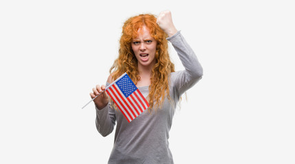 Poster - Young redhead woman holding flag of United States of America annoyed and frustrated shouting with anger, crazy and yelling with raised hand, anger concept