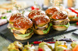 © iushakovsky - Set of meat burgers on black board on wooden table