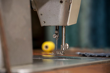 An old household sewing machine with a blue thread coil and oil tracks. World of hobbies