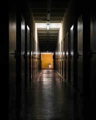 Dimly lit hallway in an abandoned storage place, dark creepy corridor