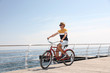 © New Africa - Attractive man riding bike near sea on sunny day