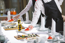 Waiter Serving Table In The Restaurant Preparing To Receive Guests.