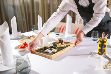 Wall Mural - Waiter serving table in the restaurant preparing to receive guests.