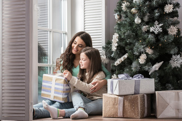 Wall Mural - Mother and daughter unwrapping gift