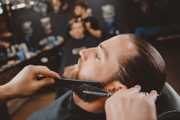 Wall Mural - Hipster client man visiting in barber shop shaving beard