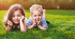 Cheerful siblings relaxing on a fresh lawn