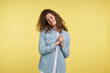 © South House Studio - Pretty and shy young brunette woman with curly hair, she is happy and joyful, against over yellow background