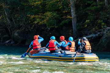 Group of young people going white water rafting