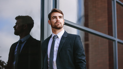 Wall Mural - Businessman standing outside and looking away