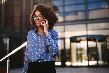 Wall Mural - Female business professional walking outside using phone