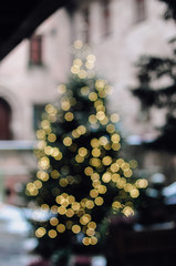 Wall Mural - Blurry, golden, illuminated Christmas fairy lights on outdoor xmas tree at the Nuremberg Christkindles market in winter creating a beautiful out of focus bokeh effekt.