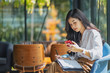 © Songsak C - Young beautiful asian woman listening to music from smartphone while relax in cafe with happiness