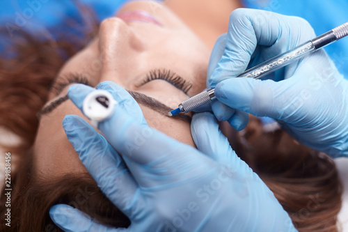 Cuadros en Lienzo microblading close-up, hands adding pigment to eyebrows.