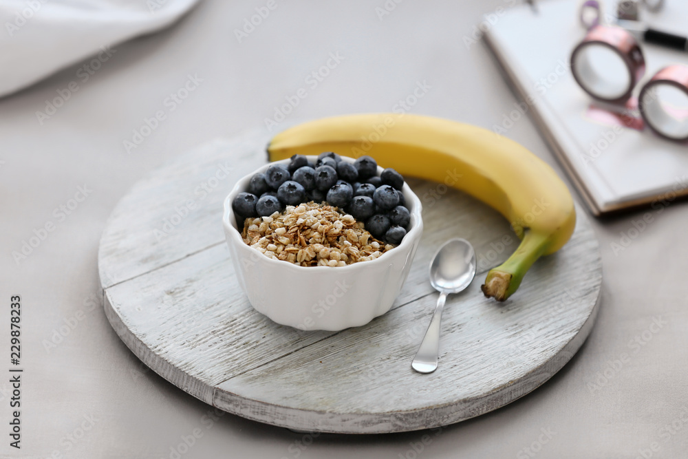 Wooden board with delicious breakfast on bed