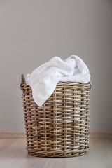 Laundry basket with dirty towels on floor