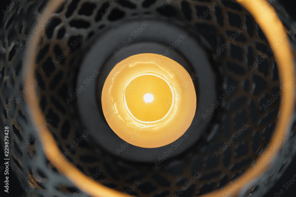 Burning candle in decorative holder, closeup