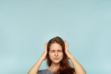 Don't Want To Hear It. Rejection Refusal And Denial. Young Woman Covering Ears With Hands. Portrait Of A Girl With Tightly Shut Eyes On Blue Background.