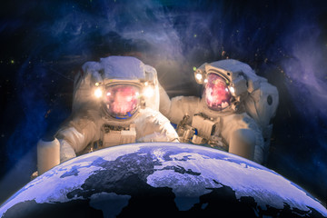Wall Mural - caring for the planet. two huge astronauts repait the planet earth against the background of the gal