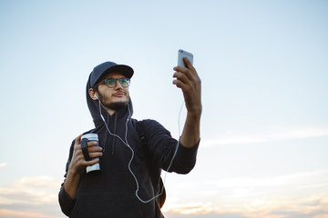 A boy takes pictures at sunset with the phone.