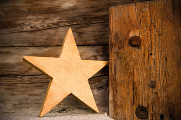 a wooden star in front of a wooden background