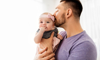 Canvas Print - family, fatherhood and people concept - close up of happy father kissing little baby daughter