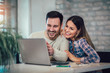 © Mediteraneo - Young Couple Using Laptop On Desk At Home