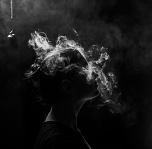Profile Of A Beautiful Girl On A Black Background. The Face Of A Girl Exhaling Smoke. Smoking Redhead Woman. Head In Hookah Smoke