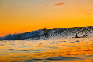 Surf girl on surfboard at sunset. Woman in ocean, sunset surfing.