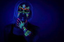 Portrait Of Woman With Ethnic Pattern, Neon Makeup In Ultraviolet Light. Body Art Design Of Female Posing In UV, Painted Face And Hand, Colourful Make Up