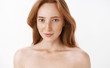 © Cookie Studio - Feminine attractive adult and slim redhead female with freckles and natural ginger hair standing naked over white background smiling sensually gazing with interest and desire at camera