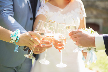 People hold in hands glasses with white wine. wedding party. friends toasting with champagne