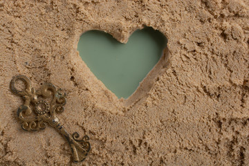 Wall Mural - Retro style key and a heart shape on brown sand