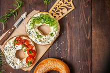 Bagels With Cream Cheese, Sesame, Tomato And Cucumber On A Wooden Board. Top View Flat Lay. With Copy Space