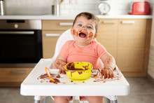 Laughing Baby Making Mess While Eating Chocolate Dessert