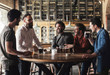 © Stocksy - Group of men laughing and drinking beer in bar
