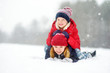 © MNStudio - Two adorable little girls having fun together in beautiful winter park. Beautiful sisters playing in a snow.