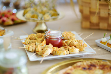 Wall Mural - Fresh and delicious chicken and cheese skewers served with sauce in a jar ion a party or wedding reception.