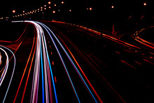 Cars Light Trails On A Curved Highway At Night. Night Traffic Trails. Motion Blur. Night City Road With Traffic Headlight Motion. Cityscape. Light Up Road By Vehicle Motion Blur.