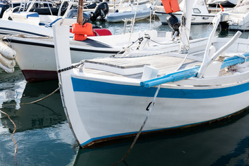 Traditional wooden boats in the harbor at mediterranean city marina port.