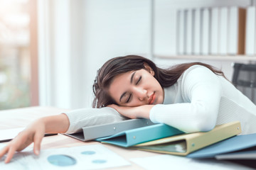 tired businesswoman sleeping with document on the desk at office. overwork, working overtime and str