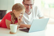 © spass - Happy young father have fun with his pretty daughter during working with laptop at home