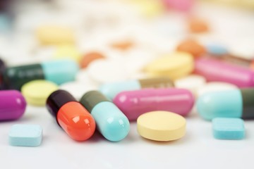 Wall Mural - close up macro Pill spilling out disrupted. colorful pills capsule on to surface tablets on a table wooden background. drug medical healthcare concept.