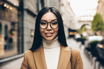 City walk. Woman portrait. Beautiful young woman is looking at camera and smiling; outdoors