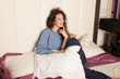 © maryadam - Young brunette woman in pajamas sitting on a bed