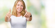 © Krakenimages.com - Beautiful young woman wearing casual white t-shirt over isolated background approving doing positive gesture with hand, thumbs up smiling and happy for success. Looking at the camera, winner gesture.
