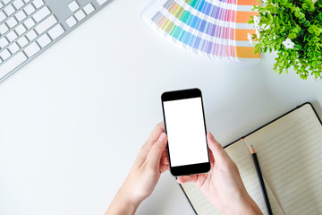 Wall Mural - Hands using smartphone on office table with top view.